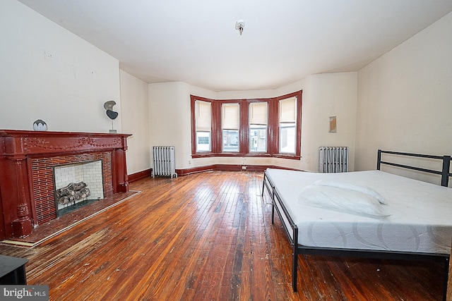 bedroom with dark hardwood / wood-style floors and radiator