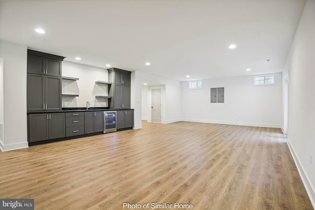 8202 Mockingbird Dr, Annandale, VA 22003 - unfurnished living room with light wood-style floors, baseboards, indoor wet bar, and beverage cooler