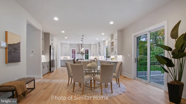 dining space with light hardwood / wood-style floors and sink