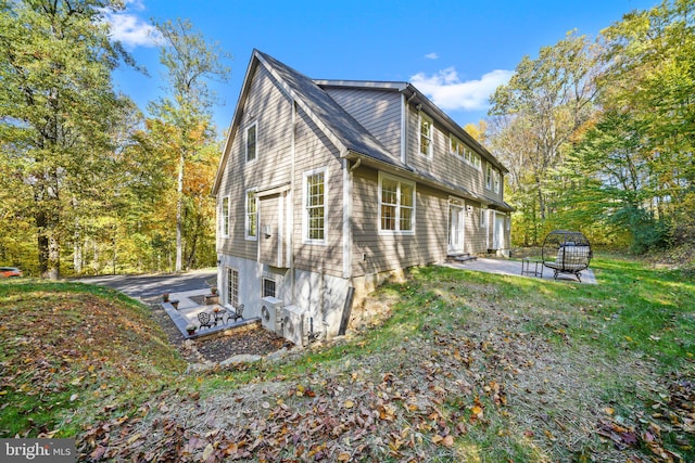 view of side of property featuring a patio and an outdoor fire pit