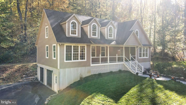 new england style home featuring a garage and a front lawn