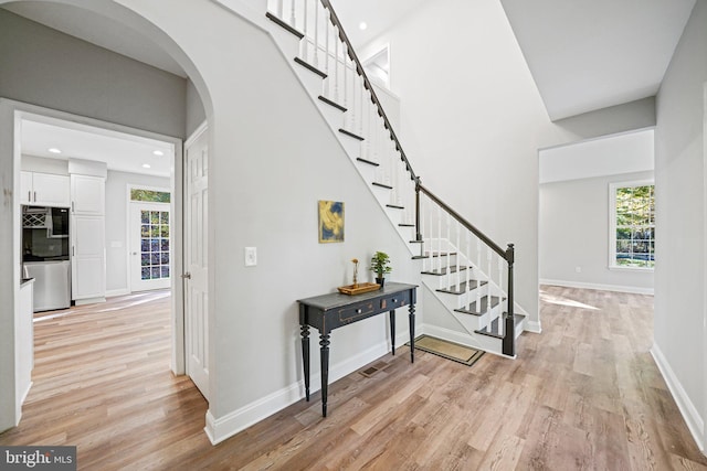 stairs with hardwood / wood-style flooring and a healthy amount of sunlight