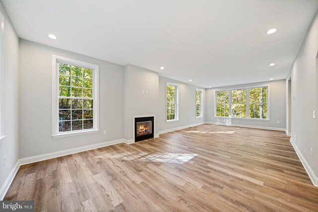 unfurnished living room with light hardwood / wood-style floors and plenty of natural light