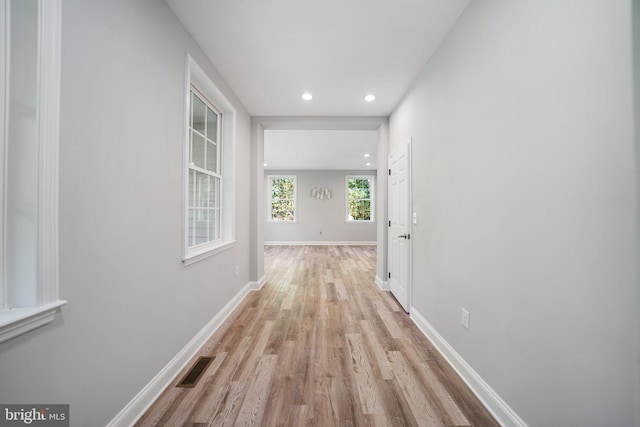 hallway with light hardwood / wood-style floors