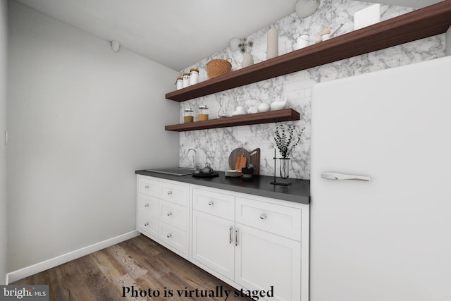 bar with white cabinetry, sink, and dark wood-type flooring