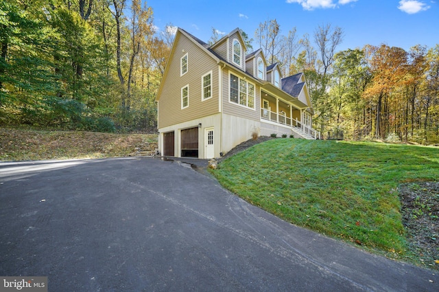 view of home's exterior featuring a porch, a yard, and a garage