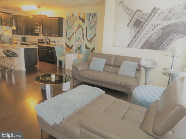 living room featuring a chandelier and dark wood-type flooring