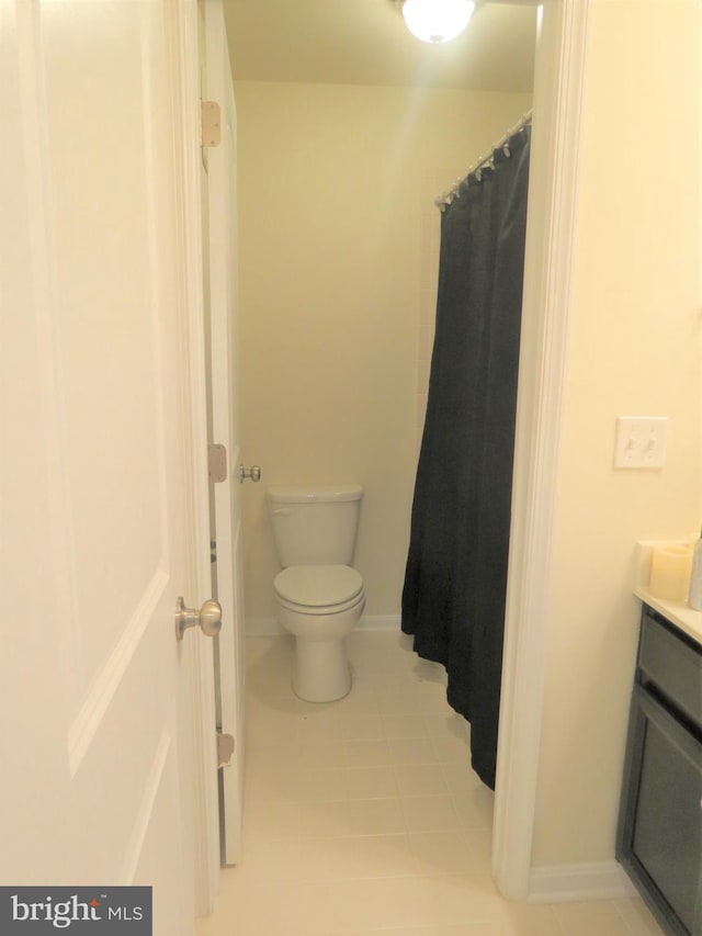 bathroom with tile patterned floors, curtained shower, vanity, and toilet