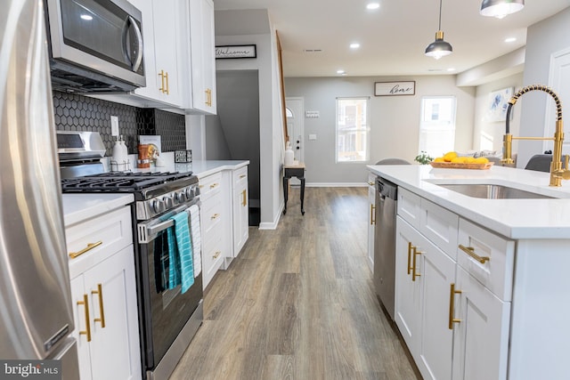 kitchen featuring white cabinets, appliances with stainless steel finishes, and sink