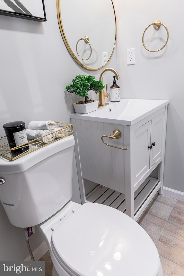 bathroom featuring vanity, hardwood / wood-style flooring, and toilet