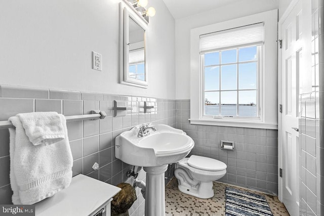 bathroom with tile walls, tile patterned floors, and toilet