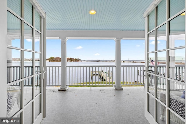 unfurnished sunroom with a wealth of natural light and a water view