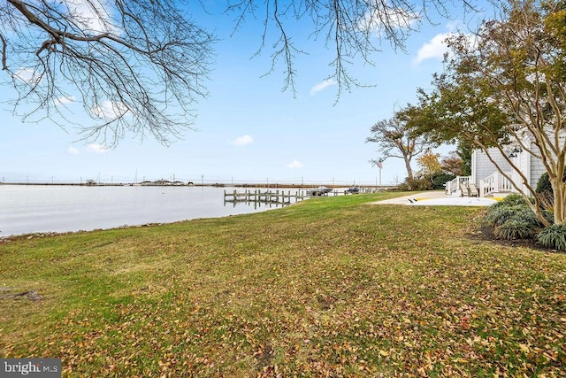 dock area with a water view, a patio, and a yard