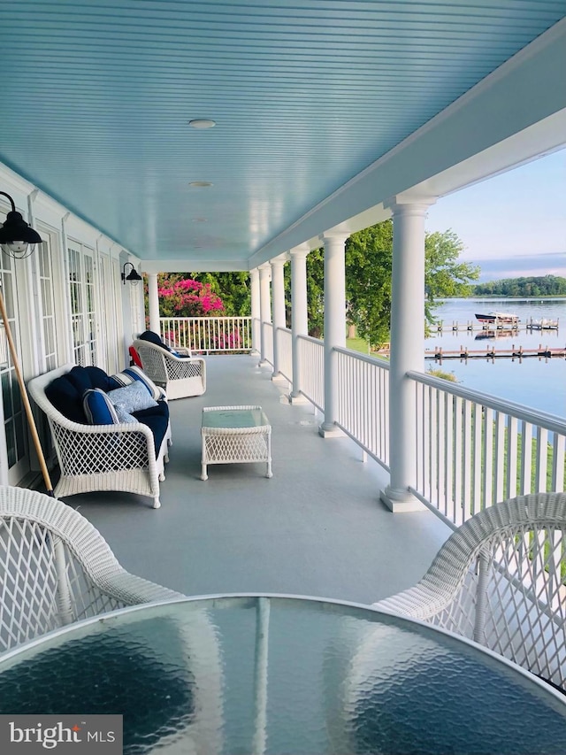 view of patio with covered porch and a water view