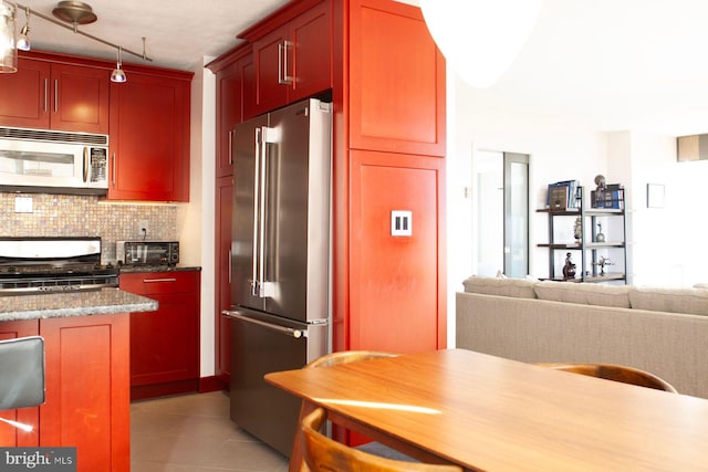 kitchen featuring light stone countertops, light tile patterned floors, backsplash, and stainless steel appliances