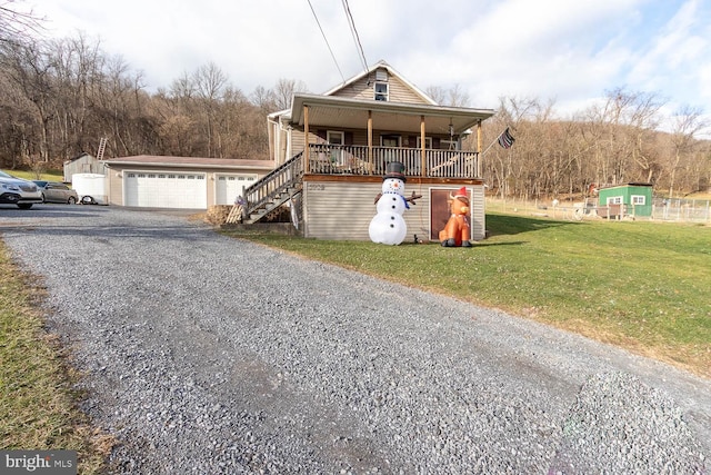 front of property featuring a porch, an outbuilding, a front yard, and a garage