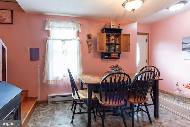 dining room featuring tile patterned floors, plenty of natural light, and a baseboard heating unit