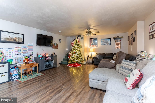 living room with ceiling fan, dark hardwood / wood-style flooring, and a textured ceiling