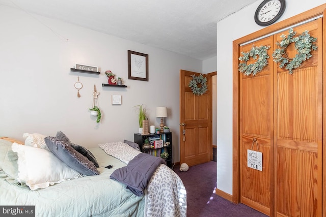 bedroom with a textured ceiling and dark carpet