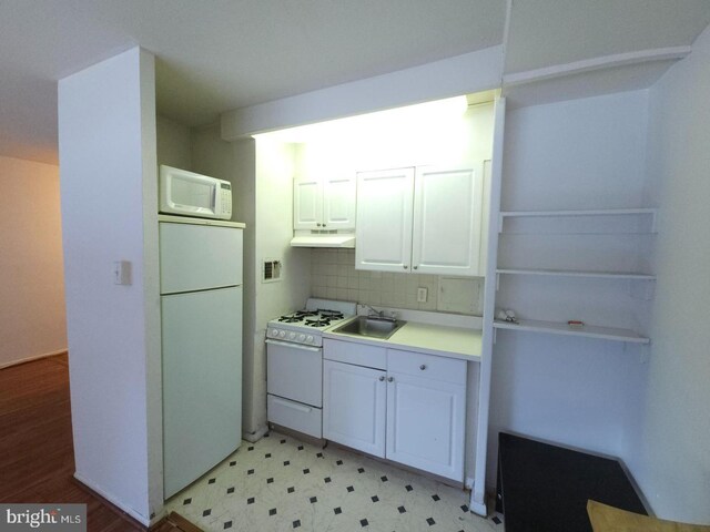 kitchen featuring white appliances, white cabinets, sink, and decorative backsplash