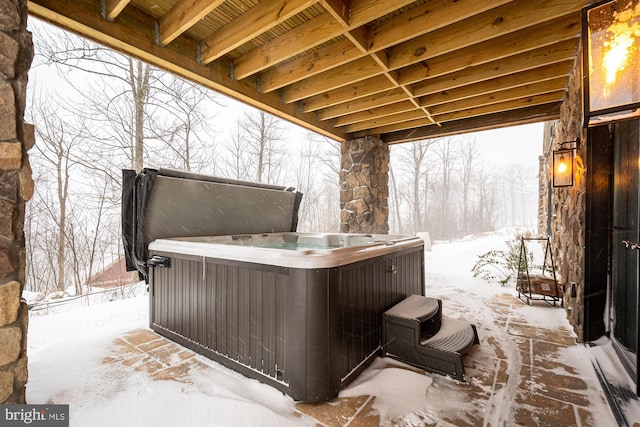 snow covered deck featuring a hot tub