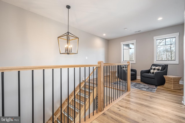 hall featuring a notable chandelier and light wood-type flooring