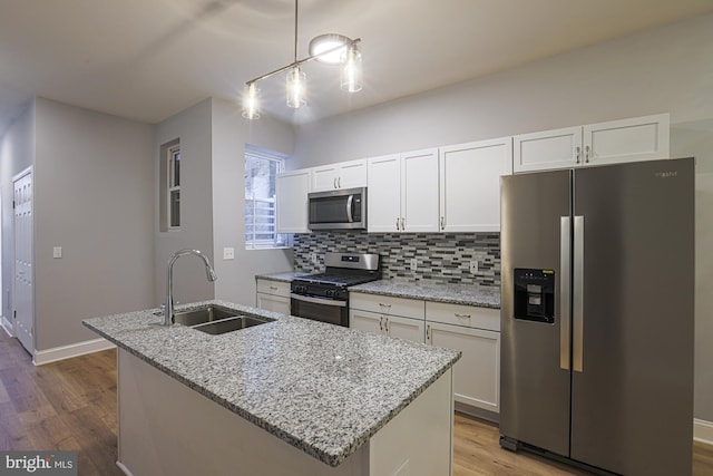 kitchen with stainless steel appliances, sink, a center island with sink, light hardwood / wood-style flooring, and white cabinets