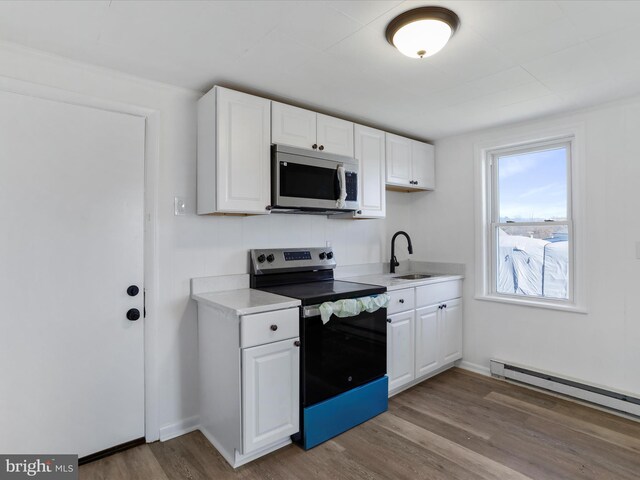 kitchen featuring stainless steel appliances, sink, a baseboard radiator, white cabinets, and light hardwood / wood-style floors