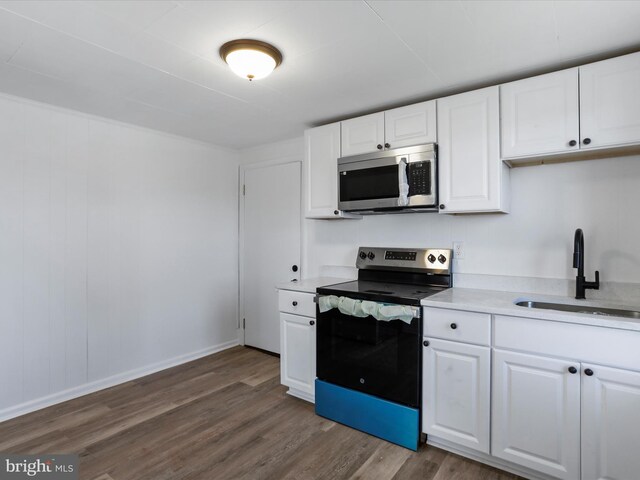 kitchen with white cabinetry, sink, stainless steel appliances, and dark hardwood / wood-style floors