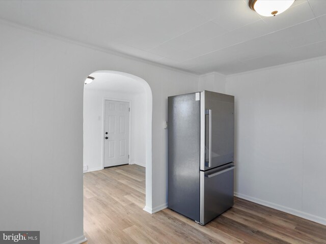 kitchen with stainless steel fridge, light hardwood / wood-style flooring, and ornamental molding