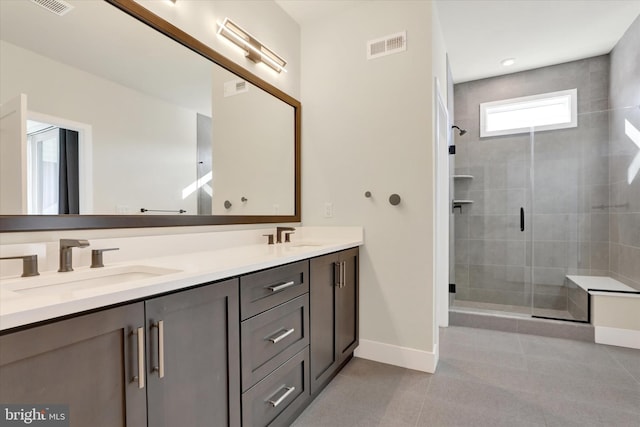 bathroom with tile patterned flooring, vanity, and a shower with door