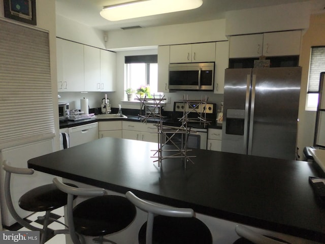 kitchen with a breakfast bar and appliances with stainless steel finishes