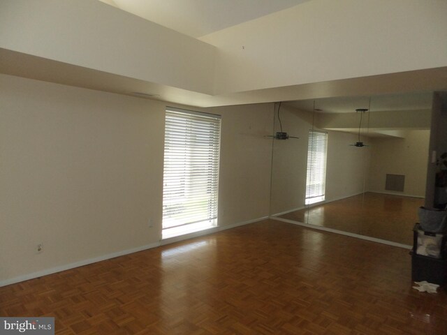 1710 Oakwood Ter Unit 3E, Penn Valley, PA 19072 - unfurnished living room with baseboards, plenty of natural light, and a towering ceiling