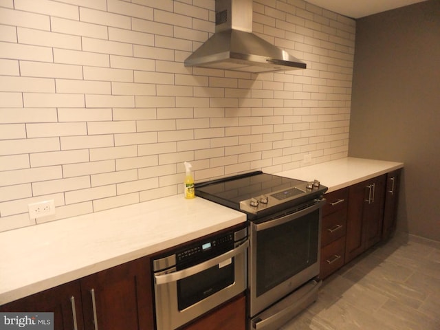 1710 Oakwood Ter Unit 3E, Penn Valley, PA 19072 - kitchen with wall chimney range hood, stainless steel electric range, light countertops, dark brown cabinetry, and decorative backsplash