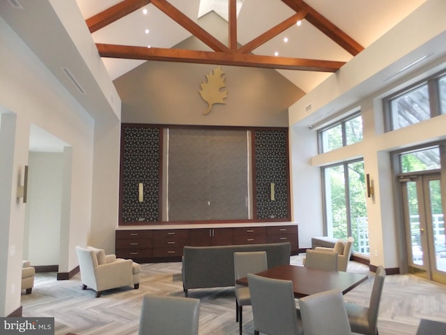 interior space with beam ceiling, light parquet floors, and high vaulted ceiling