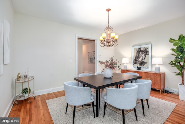 dining space with a notable chandelier and light wood-type flooring