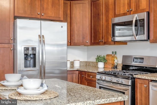 kitchen featuring light stone counters and stainless steel appliances