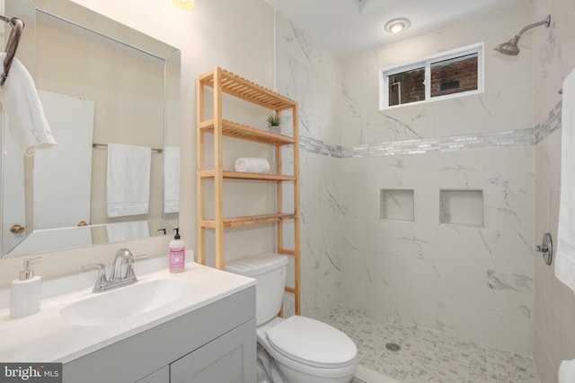 bathroom featuring tiled shower, vanity, and toilet