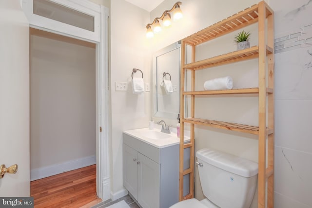 bathroom featuring vanity, wood-type flooring, and toilet