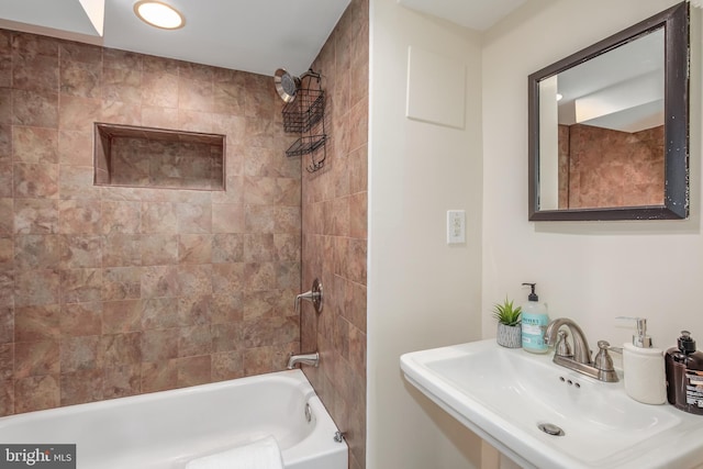 bathroom featuring tiled shower / bath combo and sink