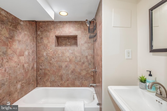 bathroom with sink and tiled shower / bath