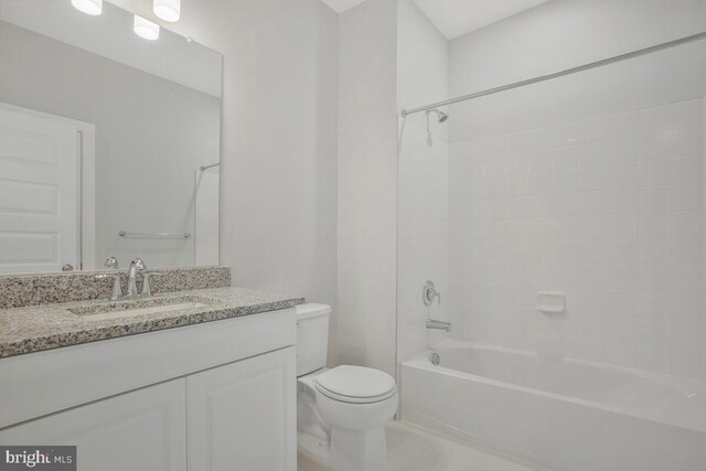 full bathroom featuring tiled shower / bath combo, toilet, and vanity