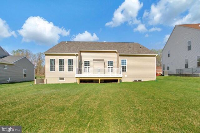 rear view of house with a wooden deck and a yard