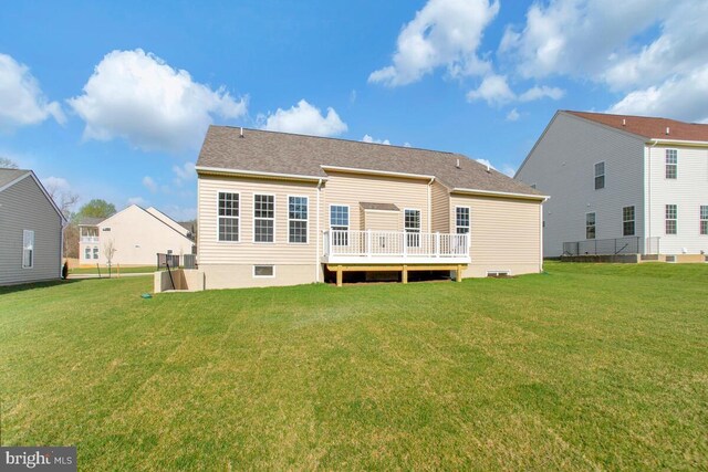 back of property with a yard and a wooden deck