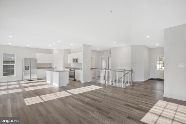 unfurnished living room featuring sink and wood-type flooring