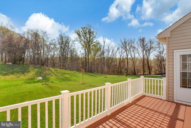 wooden deck featuring a lawn