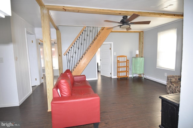 living room with dark hardwood / wood-style floors, ceiling fan, crown molding, and beam ceiling