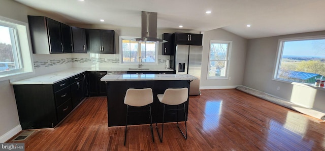 kitchen with island exhaust hood, a center island, and a wealth of natural light