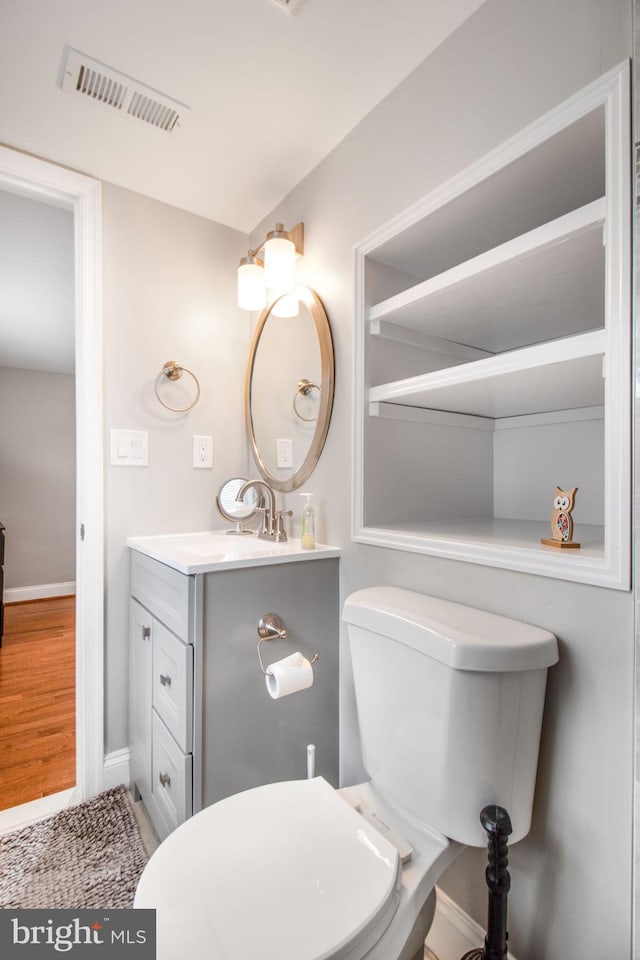 bathroom featuring hardwood / wood-style floors, vanity, and toilet