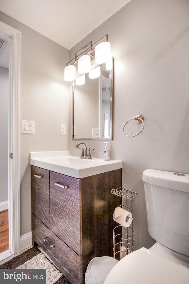 bathroom featuring vanity, hardwood / wood-style flooring, and toilet